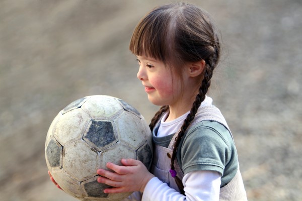 Tjej som håller i en fotboll